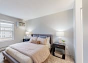 Thumbnail 53 of 83 - a white bedroom with a large bed and a window at Audenn Apartments, Bloomington, MN