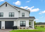 Thumbnail 42 of 113 - A white house with a black garage door.