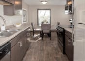 Thumbnail 4 of 28 - one plus den model, dining and kitchen with new slate cabinetry, stainless steel appliances
