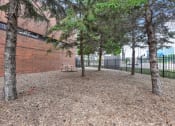 Thumbnail 45 of 53 - a park with trees and a bench in front of a brick building