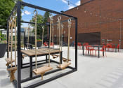 Thumbnail 43 of 53 - a large wooden table and chairs in a courtyard with a brick building in the background