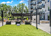 Thumbnail 8 of 71 - A park area with a bench and a tree in a planter box.