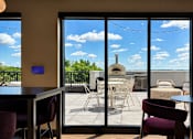 Thumbnail 20 of 88 - A patio with a table and chairs is visible through a glass door.