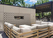 Thumbnail 23 of 88 - A wooden outdoor seating area with a patterned wall and a wooden pergola.