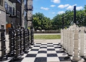 Thumbnail 18 of 88 - A giant chess set is set up on a checkered floor.