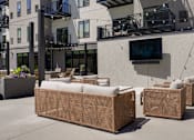 Thumbnail 15 of 88 - Two brown wicker sofas are placed on a patio in front of a building.