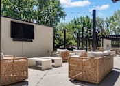 Thumbnail 22 of 88 - A patio area with wicker furniture and a television on a wall.