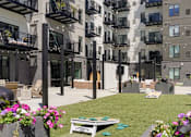 Thumbnail 9 of 88 - A construction site is in the middle of a grassy area with apartment buildings in the background.