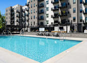 Thumbnail 14 of 88 - A swimming pool in front of apartment buildings.