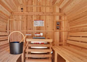 Thumbnail 17 of 88 - A wooden sauna with a bucket and a towel on the bench.