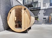 Thumbnail 16 of 88 - A modern wooden structure with a circular design is situated in an urban setting.