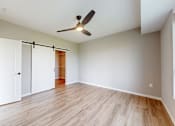 Thumbnail 41 of 65 - an empty living room with a ceiling fan and a closet at Ardor on the Bluffs South Loop Residences Apartments, Minnesota