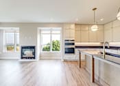 Thumbnail 39 of 65 - a large kitchen with a fireplace and a large island at Ardor on the Bluffs South Loop Residences Apartments, Bloomington, MN, 55425