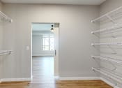 Thumbnail 42 of 65 - a walk in closet in a home with white walls and a door to a room at Ardor on the Bluffs South Loop Residences Apartments, Minnesota