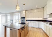 Thumbnail 37 of 65 - a large kitchen with an island in the middle at Ardor on the Bluffs South Loop Residences Apartments, Bloomington, MN