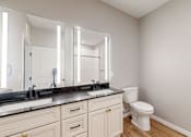 Thumbnail 43 of 65 - a bathroom with a toilet and a sink and a mirror at Ardor on the Bluffs South Loop Residences Apartments, Bloomington, 55425