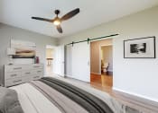 Thumbnail 3 of 65 - a bedroom with a bed and a ceiling fan at Ardor on the Bluffs South Loop Residences Apartments, Bloomington, 55425