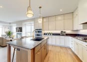 Thumbnail 2 of 65 - a large kitchen with an island and a living room at Ardor on the Bluffs South Loop Residences Apartments, Bloomington, MN, 55425