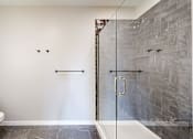 Thumbnail 51 of 65 - a bathroom with a toilet and a glass shower at Ardor on the Bluffs South Loop Residences Apartments, Minnesota, 55425