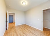 Thumbnail 52 of 65 - a bedroom with a door to a closet and a hard wood floor at Ardor on the Bluffs South Loop Residences Apartments, Bloomington, Minnesota