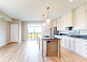 Thumbnail 46 of 65 - an open kitchen and living room with a wood floor at Ardor on the Bluffs South Loop Residences Apartments, Bloomington, MN, 55425