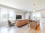 Thumbnail 5 of 65 - an open living room with a kitchen and a tv at Ardor on the Bluffs South Loop Residences Apartments, Minnesota