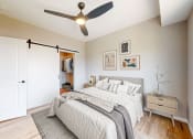 Thumbnail 6 of 65 - a bedroom with a bed and a ceiling fan at Ardor on the Bluffs South Loop Residences Apartments, Minnesota, 55425