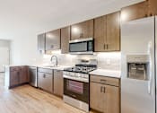 Thumbnail 55 of 65 - a kitchen with stainless steel appliances and wooden cabinets at Ardor on the Bluffs South Loop Residences Apartments, Bloomington