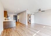 Thumbnail 56 of 65 - an empty living room with a kitchen and a washer and dryer at Ardor on the Bluffs South Loop Residences Apartments, Minnesota