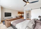 Thumbnail 18 of 65 - a bedroom with a couch and a tv at Ardor on the Bluffs South Loop Residences Apartments, Bloomington