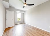 Thumbnail 64 of 65 - an empty living room with wood floors and a ceiling fan at Ardor on the Bluffs South Loop Residences Apartments, Bloomington, Minnesota