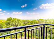 Thumbnail 61 of 65 - a balcony with a view of trees and a blue sky at Ardor on the Bluffs South Loop Residences Apartments, Bloomington, MN, 55425