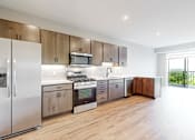 Thumbnail 60 of 65 - a kitchen with stainless steel appliances and wooden cabinets at Ardor on the Bluffs South Loop Residences Apartments, Bloomington, MN