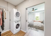 Thumbnail 10 of 65 - a washer and dryer in a closet in a bedroom at Ardor on the Bluffs South Loop Residences Apartments, Bloomington, Minnesota