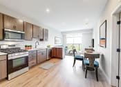 Thumbnail 8 of 65 - a large kitchen with wooden cabinets and stainless steel appliances at Ardor on the Bluffs South Loop Residences Apartments, Minnesota