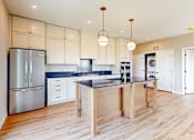 Thumbnail 26 of 76 - A modern kitchen with wooden floors and stainless steel appliances.