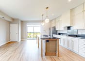 Thumbnail 28 of 76 - A kitchen with white cabinets and a wooden island.