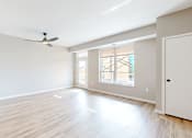 Thumbnail 23 of 76 - A spacious room with a ceiling fan and sliding glass doors.