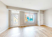 Thumbnail 24 of 76 - A spacious room with wooden flooring and a view of a balcony through the glass door.