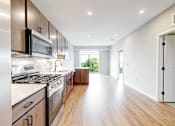 Thumbnail 19 of 76 - A modern kitchen with wooden floors and stainless steel appliances.