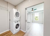 Thumbnail 21 of 76 - A white washer and dryer in a laundry room.