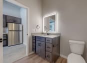Thumbnail 28 of 65 - A bathroom with a toilet, sink, and mirror. at Ardor on the Bluffs South Loop Residences Apartments, Minnesota, 55425
