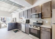 Thumbnail 14 of 65 - kitchen with tile backsplash, breakfast counter backed up to a living room area at Ardor on the Bluffs South Loop Residences Apartments, Minnesota
