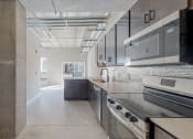Thumbnail 20 of 65 - A modern kitchen with stainless steel appliances and a large island at Ardor on the Bluffs South Loop Residences Apartments, Bloomington, MN, 55425