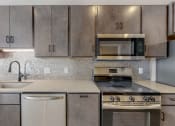 Thumbnail 21 of 65 - an empty kitchen with stainless steel appliances and cabinets at Ardor on the Bluffs South Loop Residences Apartments, Bloomington, MN