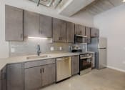 Thumbnail 22 of 65 - a kitchen with stainless steel appliances and a sink and a refrigerator at Ardor on the Bluffs South Loop Residences Apartments, Minnesota