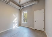 Thumbnail 33 of 65 - an empty room with a door and a window at Ardor on the Bluffs South Loop Residences Apartments, Bloomington