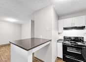 Thumbnail 15 of 83 - A kitchen with a black stove top oven and a white counter.