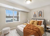 Thumbnail 2 of 32 - A bedroom with a large bed and a window overlooking a parking lot.