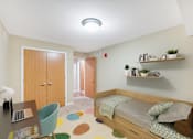Thumbnail 9 of 32 - A bedroom with a bed, desk, chair, and shelves.